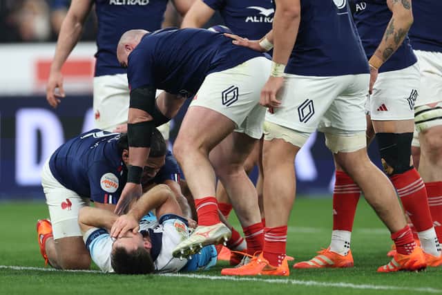 Ben White, grounded, holds his face after France's Peato Mauvaka had launched himself at the Scotland scrum-half.