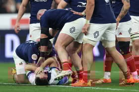 Ben White, grounded, holds his face after France's Peato Mauvaka had launched himself at the Scotland scrum-half.