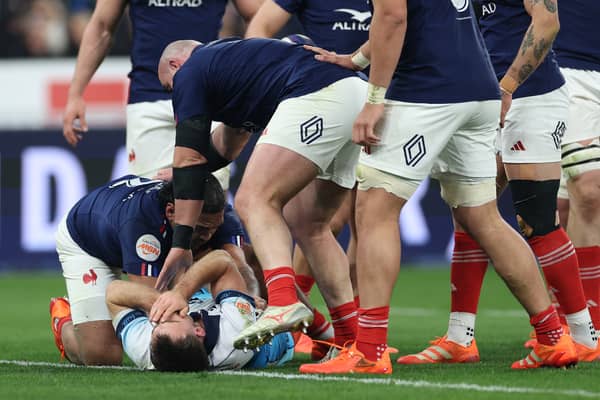 Ben White, grounded, holds his face after France's Peato Mauvaka had launched himself at the Scotland scrum-half.