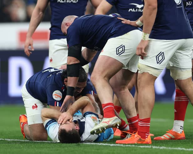Ben White, grounded, holds his face after France's Peato Mauvaka had launched himself at the Scotland scrum-half.