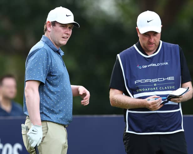Bob MacIntyre talks tactics with caddie Mike Burrown during the second round of the Porsche Singapore Classic at Laguna National Golf Resort Club  