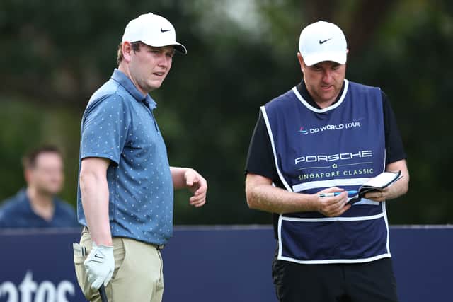 Bob MacIntyre talks tactics with caddie Mike Burrown during the second round of the Porsche Singapore Classic at Laguna National Golf Resort Club