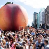 As part of a celebration of Cardiff-born author Roald Dahl, a giant peach makes its way through the streets of the city (Picture: Matt Cardy)