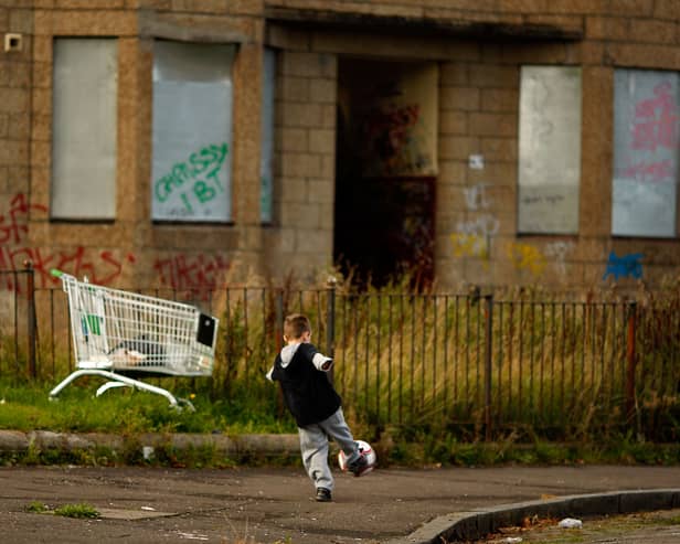 A young boy play football in the street in the Govan area of Glasgow