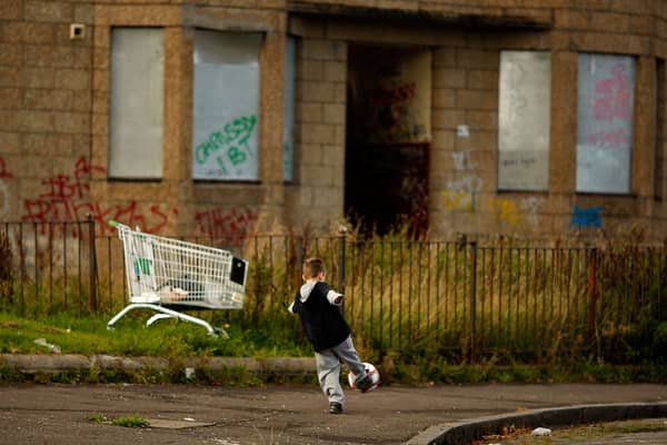 A young boy play football in the street in the Govan area of Glasgow