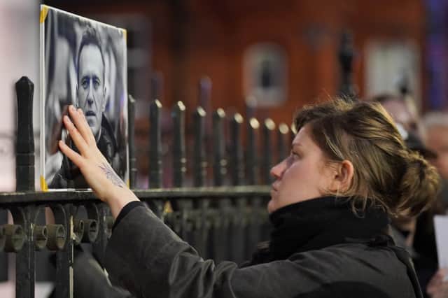 A woman touches a picture of Alexei Navalny at a protest opposite the Russian Embassy in London after the jailed Russian opposition leader died in prison. He was almost certainly murdered (Picture: Jonathan Brady)