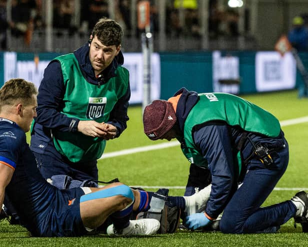 Edinburgh's Duhan van der Merwe receives medical attention after injuring his ankle against the Dragons.