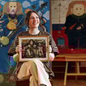 Charlotte Riordan, head of contemporary art at Lyon & Turnbull, holding a painting by the late John Byrne of The Beatles, which shows each Beatle seated beside a 'spirit animal'. Picture: Stewart Attwood/Lyon & Turnbull/PA Wire