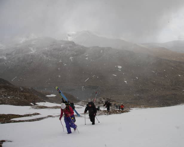 As a blizzard begins, competitors make their way to the contest face on Meall nan Tarmachan for the inaugural Lawers of Gravity freeride ski and snowboard event in 2015. 