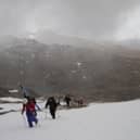 As a blizzard begins, competitors make their way to the contest face on Meall nan Tarmachan for the inaugural Lawers of Gravity freeride ski and snowboard event in 2015. 