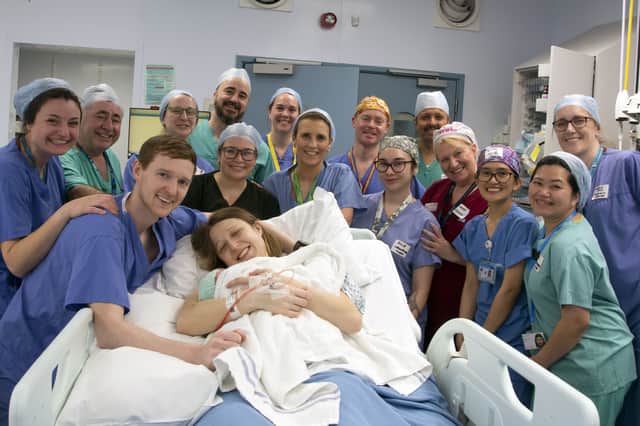 Grace and Angus Davidson (front) with the hospital team following the birth of baby Amy Isabel Davidson (Picture: Womb Transplant UK)