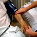 A nurse taking the blood pressure of an elderly patient