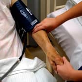 A nurse taking the blood pressure of an elderly patient