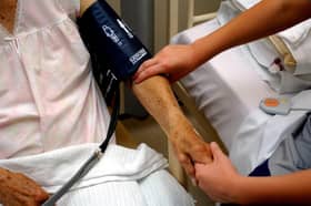 A nurse taking the blood pressure of an elderly patient
