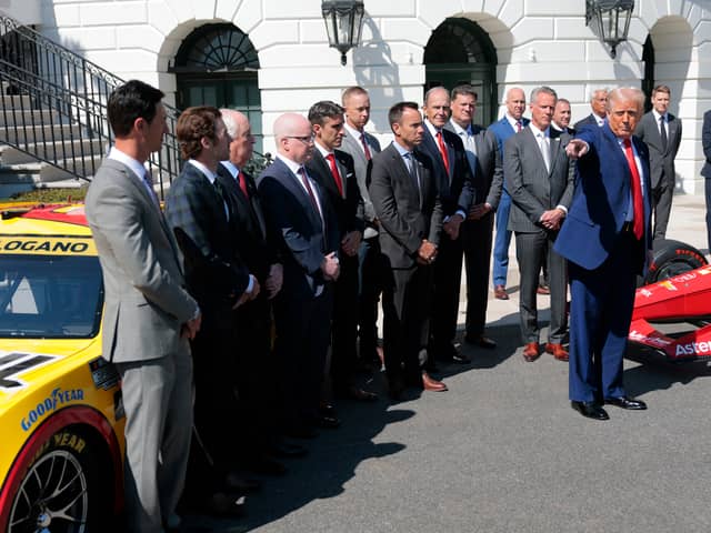 President Donald Trump gestures as he speaks to the media during a photo opportunity at the White House on Wednesday, as he hosts racing car drivers and team owners for a visit