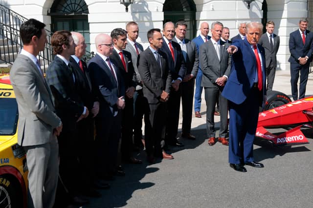 President Donald Trump gestures as he speaks to the media during a photo opportunity at the White House on Wednesday, as he hosts racing car drivers and team owners for a visit