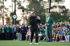 Honorary Starter Gary Player of South Africa plays his shot from the first tee at Augusta National Golf Club watched by Masters chairman Fred Ridley 