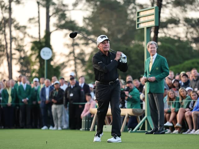 Honorary Starter Gary Player of South Africa plays his shot from the first tee at Augusta National Golf Club watched by Masters chairman Fred Ridley 