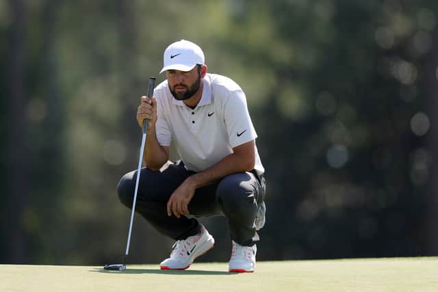 Defending champion Scottie Scheffler lines up a putt during the opening round of the 89th Masters