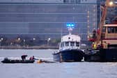 Divers investigate the scene where a helicopter crashed into the Hudson River