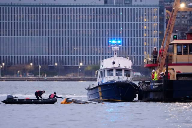 Divers investigate the scene where a helicopter crashed into the Hudson River
