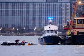 Divers investigate the scene where a helicopter crashed into the Hudson River