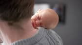 Baby Amy Isabel, seen on her father Angus Davidson's shoulder, was born after her mother, Grace Davidson, had a womb transplant (Picture: Womb Transplant UK)