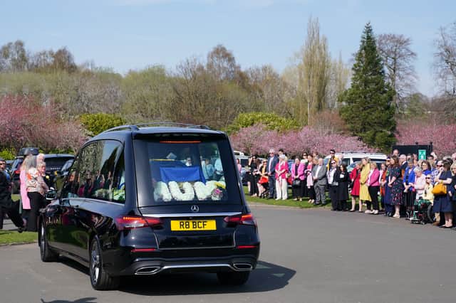 Mourners watch as the hearse carrying Scottish Government minister Christina McKelvie arrives at Daldowie crematorium in Glasgow