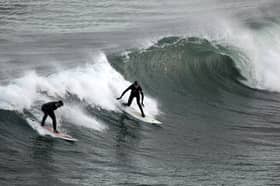 Surfers harness wave power in their own way at Coldingham Bay (Picture: Jeff J Mitchell)