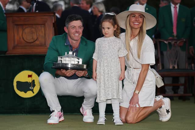 Wearing his new Green Jacket, Rory McIlroy shows off the trophy with daughter Poppy and wife Erica at Augusta National Golf Club 