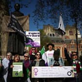 Activists sing as they hold placards including "women are born, not some bloke with a form" and "women are women, men are men, you can't change sex with the stroke of a pen" during a protest in Parliament Square across from the Supreme Court in London. Picture: Henry Nicholls/AFP via Getty Images