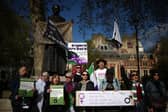 Activists sing as they hold placards including "women are born, not some bloke with a form" and "women are women, men are men, you can't change sex with the stroke of a pen" during a protest in Parliament Square across from the Supreme Court in London. Picture: Henry Nicholls/AFP via Getty Images