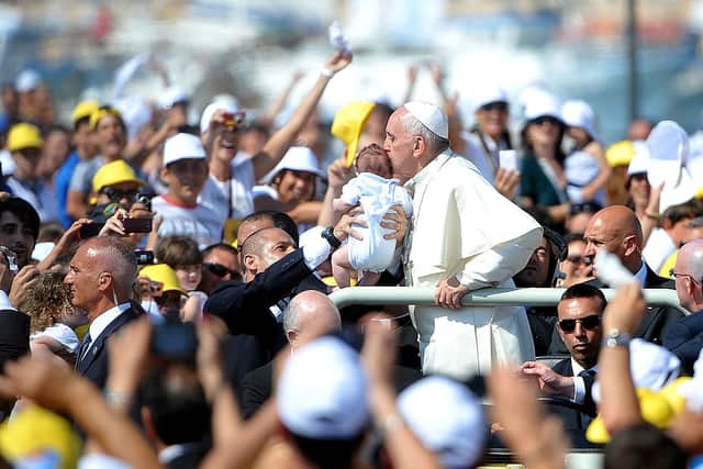Pope Francis kisses a child as he arrives on the island of Lampedusa, Italy. Picture: Tullio M. Puglia/Getty Images