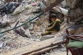 A young Palestinian boy sits amid the debris of a bombed building in Gaza City in March (Picture: Omar Al-Qattaa)