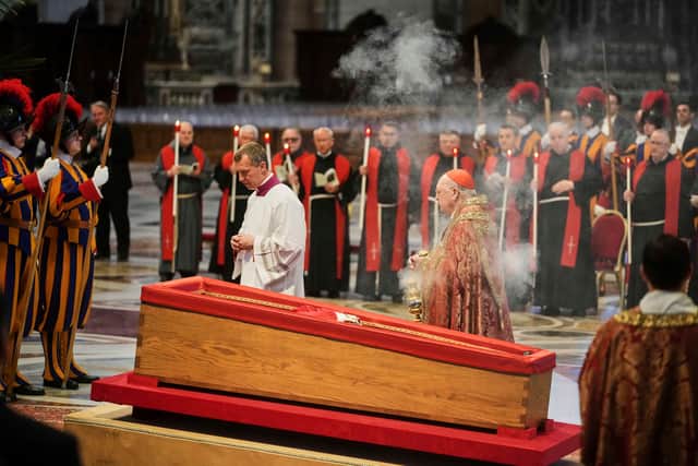 Cardinal Camerlengo Kevin Joseph Farrell, centre right, spreads incense around the body of Pope Francis inside St. Peter's Basilica at the Vatican. Picture: AP Photo/Alessandra Tarantino