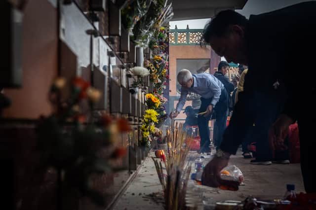 People place offerings on the graves of their ancestors during the annual Qingming festival, or Tomb Sweeping Day, at the United Chinese Cemetery in Macau on 4 April 2025.