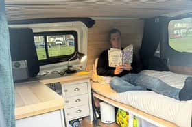 Dom Wright reads inside the back of his converted Ford Transit van