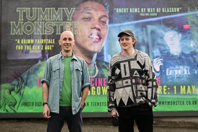 Filmmaker Ciaran Lyons and lead actor Lorn Macdonald stand at the billboard promoting film, Tummy Monster.