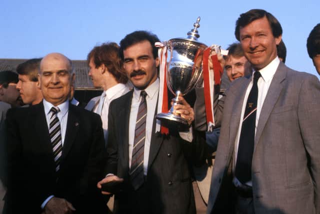 Aberdeen captain Willie Miller (centre) with the Premier League Trophy in May 1985 after presentation by League President David Letham (left). Surrounded by manager Alex Ferguson (right) and the Aberdeen squad.