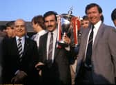 Aberdeen captain Willie Miller (centre) with the Premier League Trophy in May 1985 after presentation by League President David Letham (left). Surrounded by manager Alex Ferguson (right) and the Aberdeen squad.