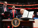 On his first day as US President, Donald Trump holds up an executive order announcing the US's withdrawal from the Paris  climate accord in the Capital One Arena in Washington (Picture: Jim Watson)