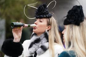 A racegoer drinks Champagne from a novel kind of flute at the Cheltenham Festival (Picture: Mike Egerton)
