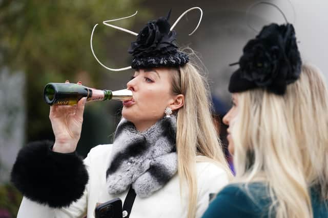 A racegoer drinks Champagne from a novel kind of flute at the Cheltenham Festival (Picture: Mike Egerton)