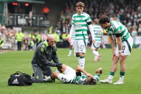 Celtic winger Jota receives treatment on a knee problem before leaving the field in the 5-0 win over Dundee United.