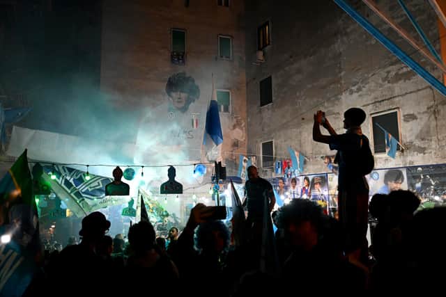 Napoli fans celebrate winning the Serie A title in 2023 alongside one of many murals of Diego Maradona in Naples, Italy. (Photo by Francesco Pecoraro/Getty Images)