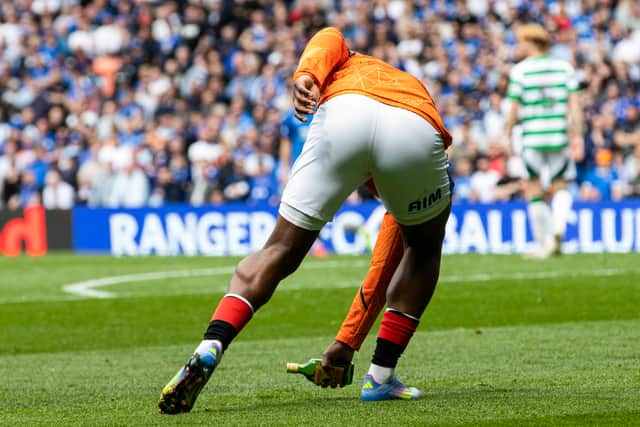 Rangers' Neraysho Kasanwirjo removes a glass bottle from the Ibrox surface.