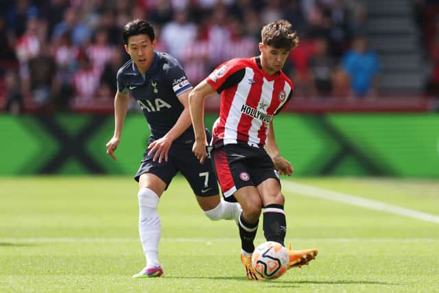 Aaron Hickey of Brentford passes the ball whilst under pressure from Heung-Min Son of Tottenham Hotspur.