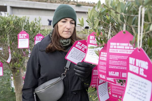 A campaigner reads notes displaying the 'dying wishes' of terminally ill people and others at an event in support of a proposed law to allow assisted dying in Scotland (Picture:  Lesley Martin)