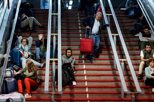 Travelers sit on the stairs as they prepare to spend the night at the Atocha train station in Madrid, following a massive power cut affecting the entire Iberian peninsula and the south of France