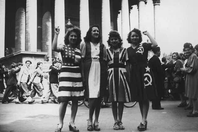 Women celebrate VE Day dressed as the flags of the USA, France, the UK and the Soviet Union in Paris on VE Day 1945 (Picture: Keystone/Hulton Archive)